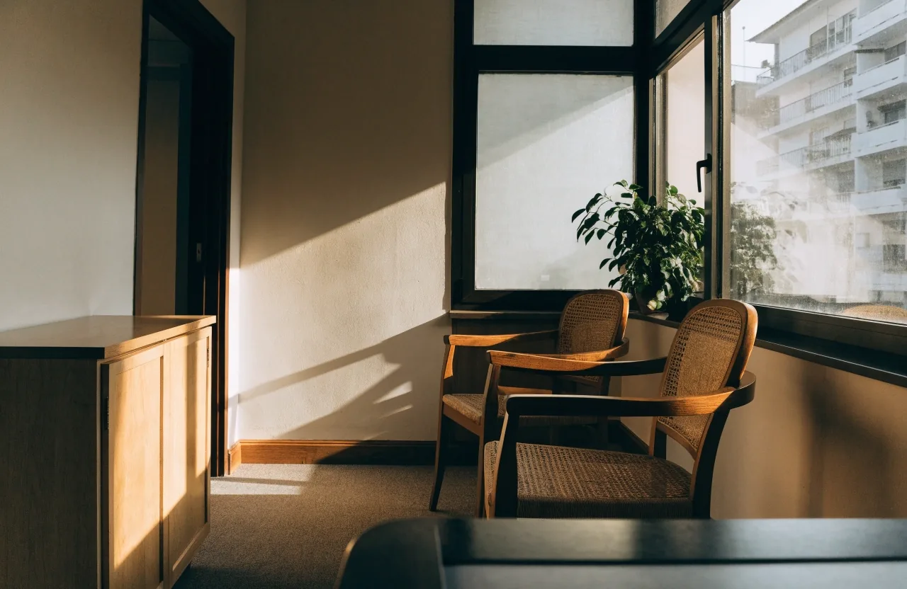 Sala de espera tranquila de un consultorio en Medellín con sillas de madera y luz de tarde